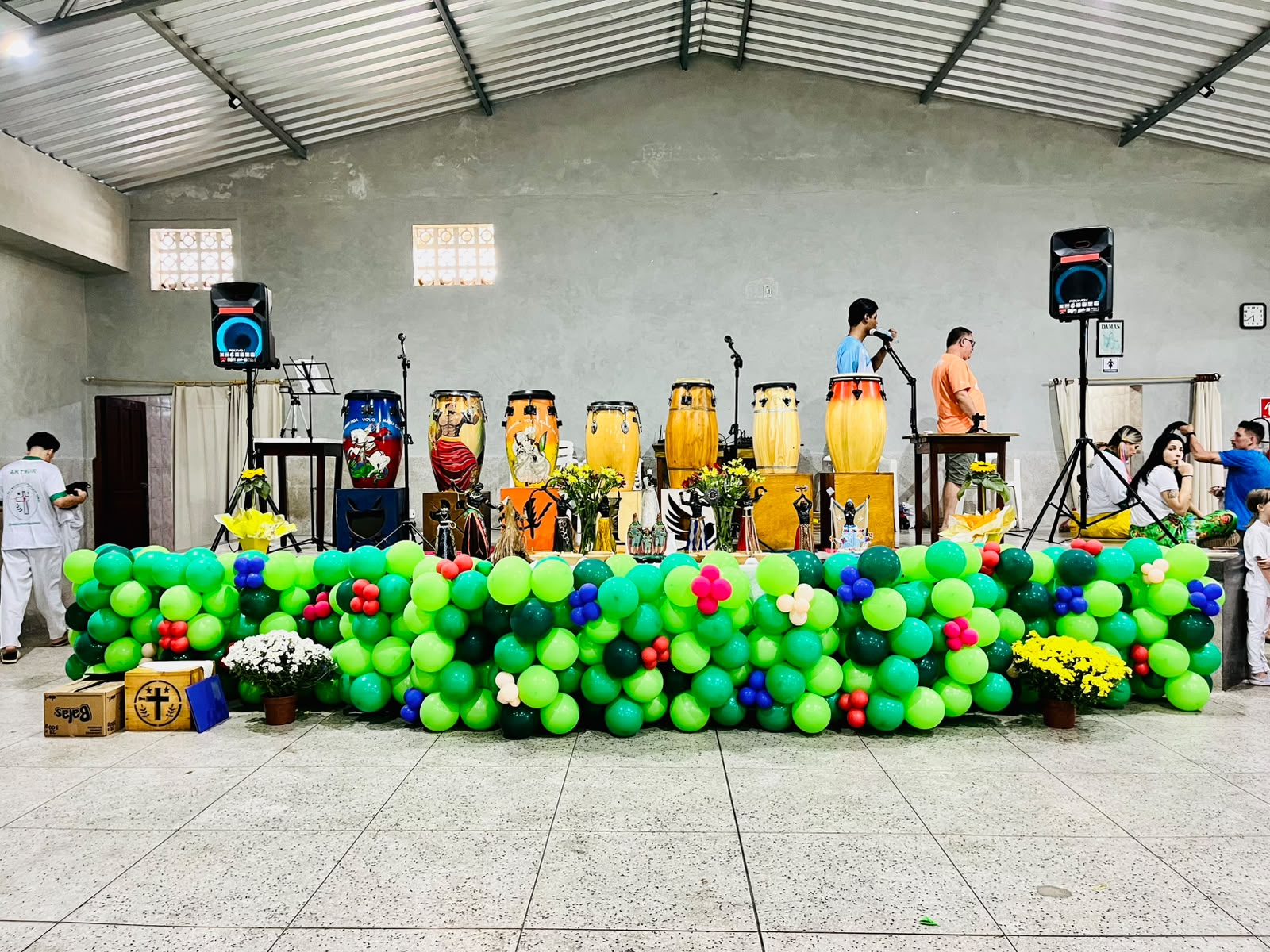 Espaço da festa decorado com balões verdes e instrumentos musicais