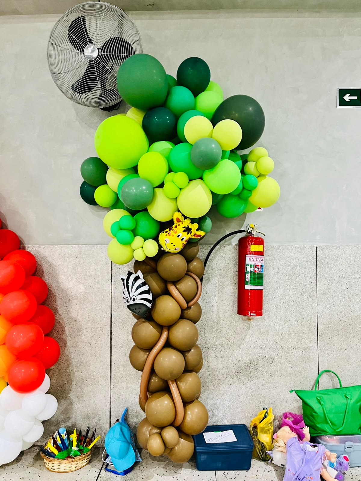 Decoração de balões verdes em formato de árvore na festa