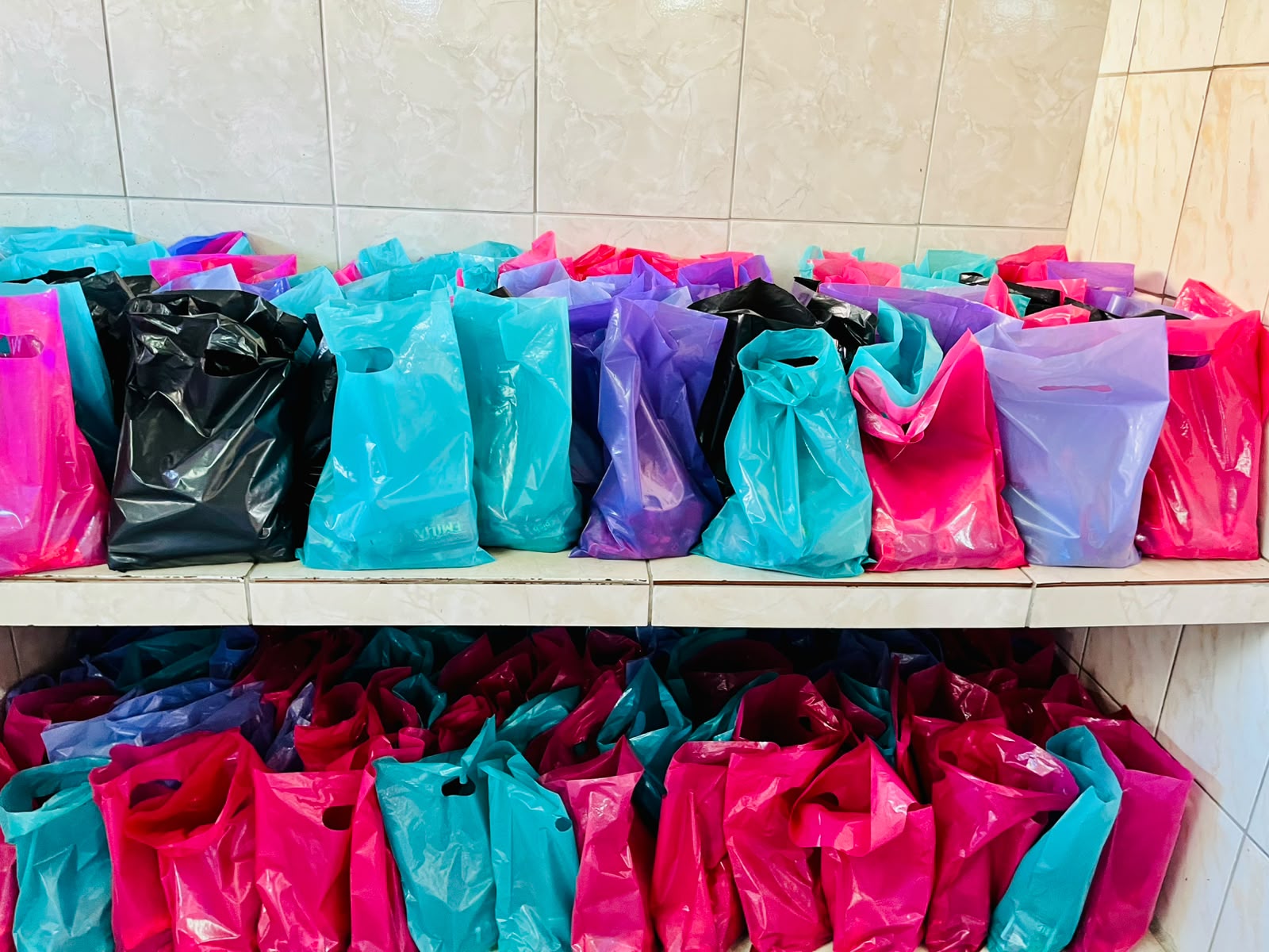Sacolas coloridas organizadas para distribuição na festa