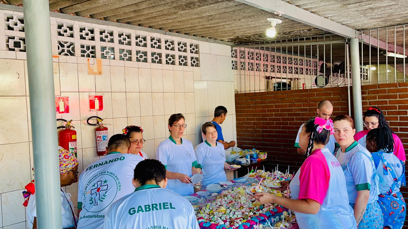 Equipe reunida ao redor da mesa de doces da festa