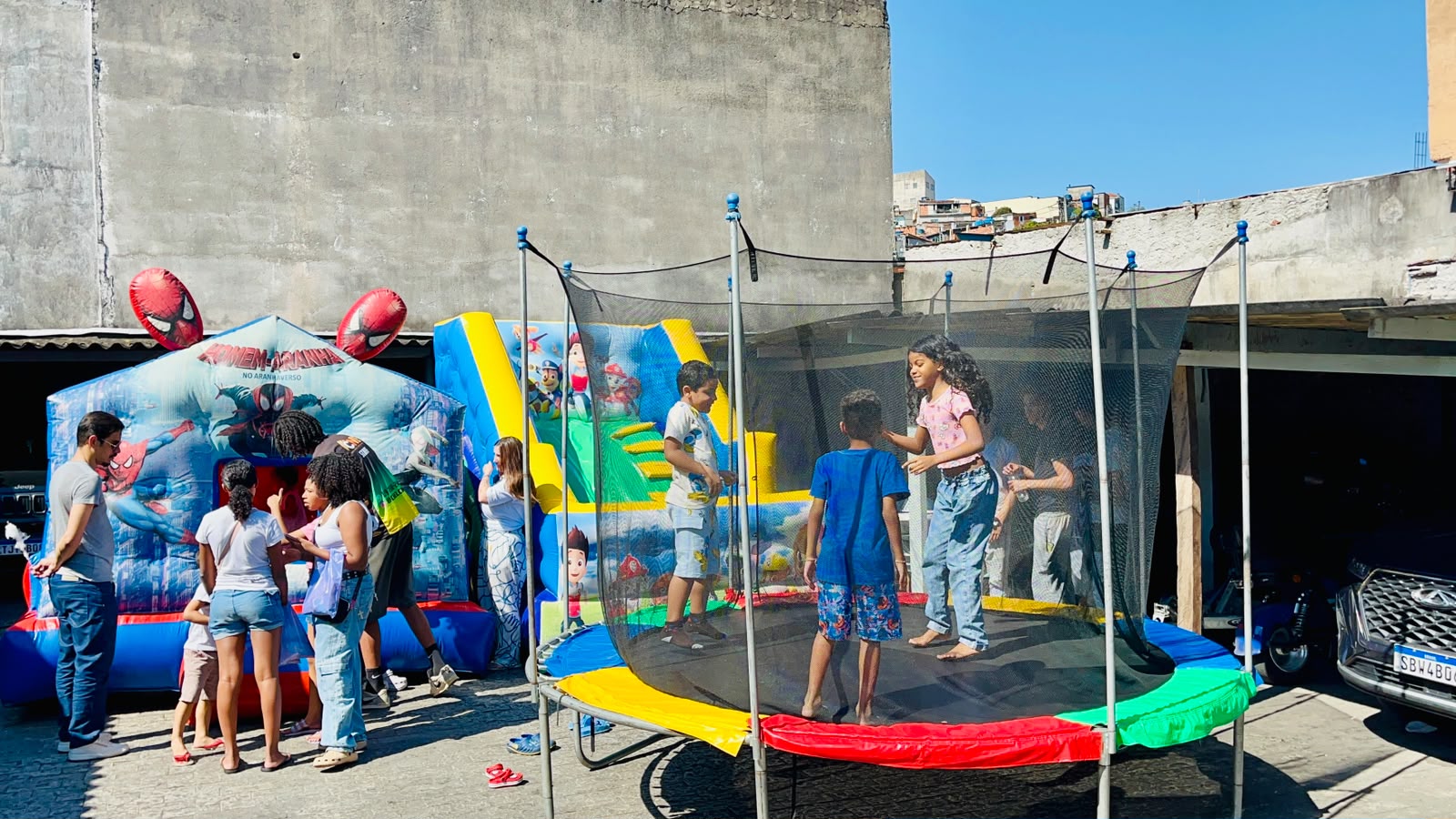 Crianças brincando na cama elástica ao lado dos infláveis