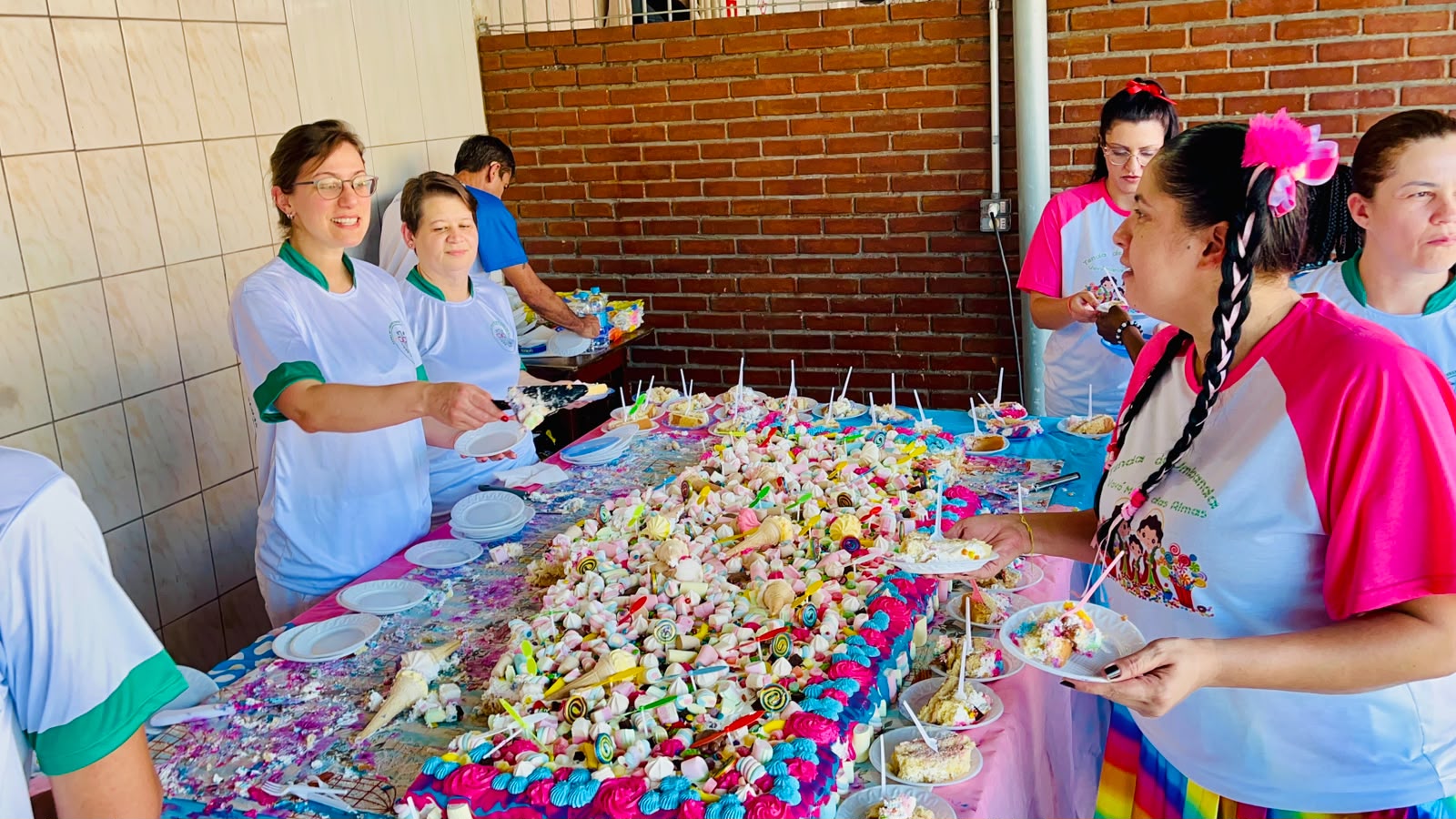Equipe compartilhando os doces preparados para a festa