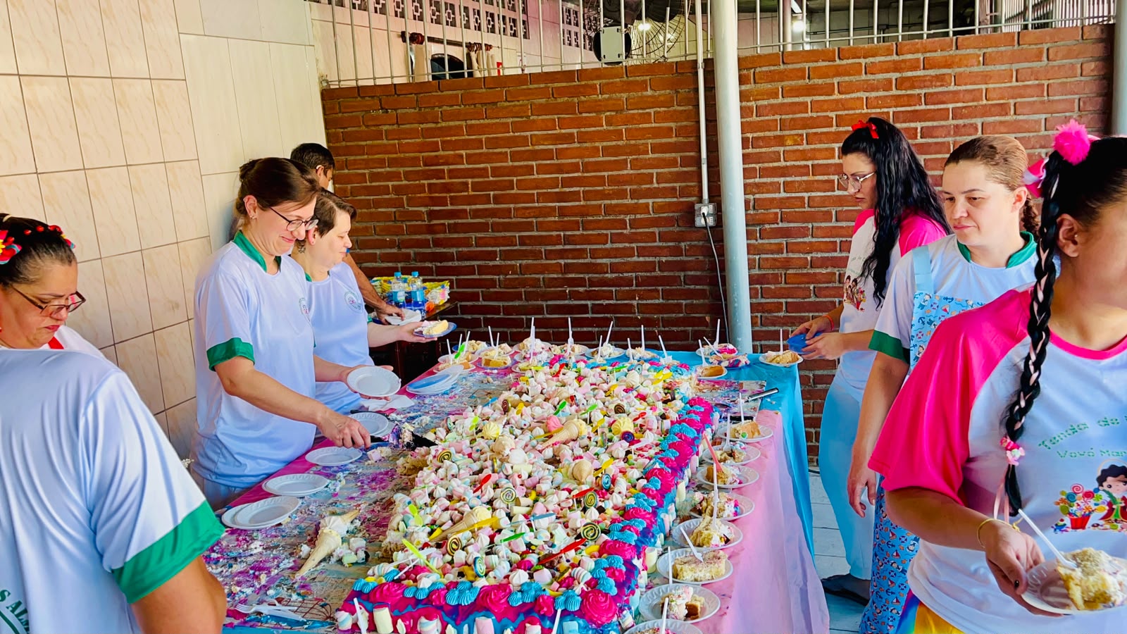 Equipe servindo doces na mesa da festa