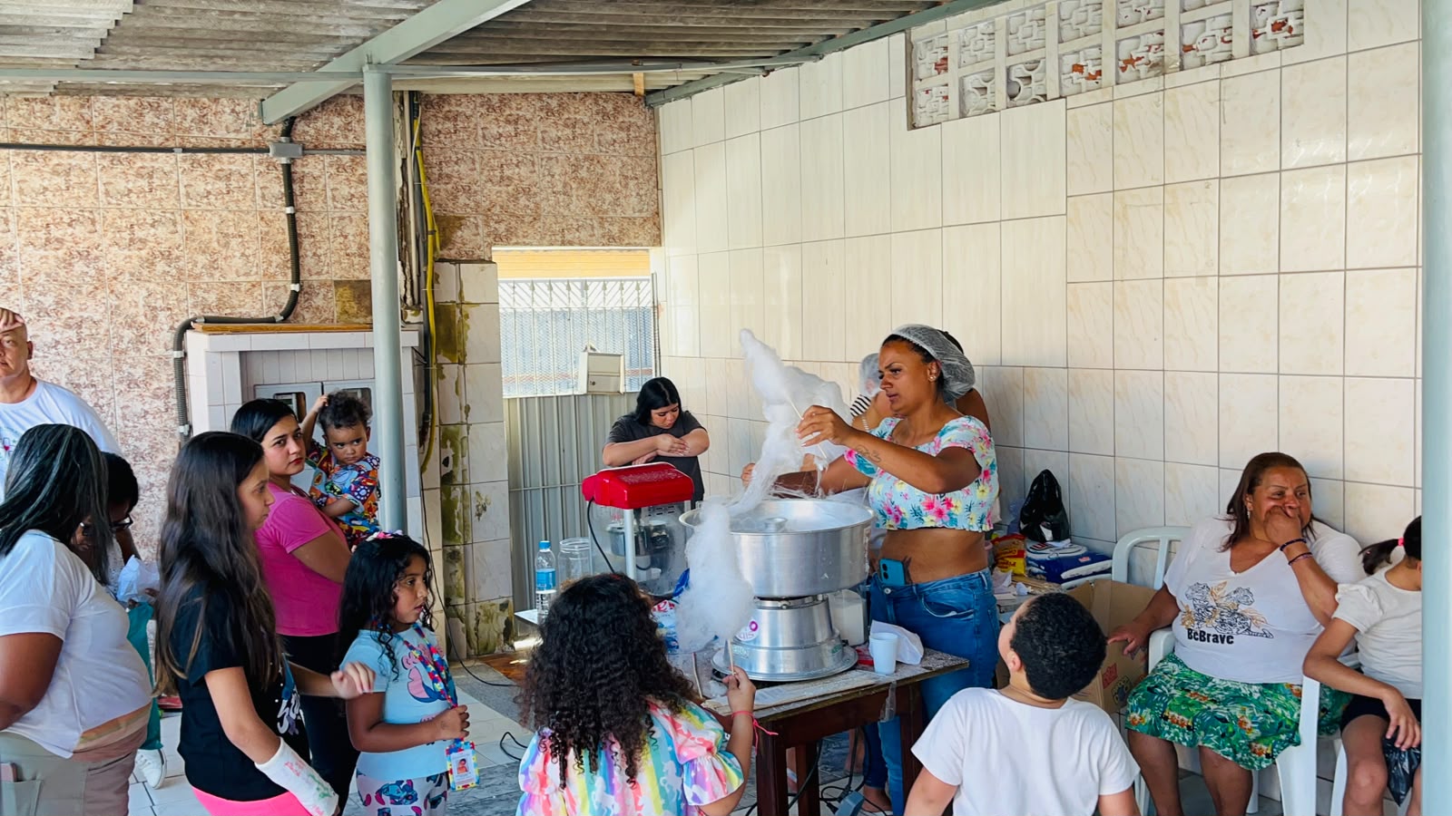 Pessoas reunidas junto à máquina de algodão-doce